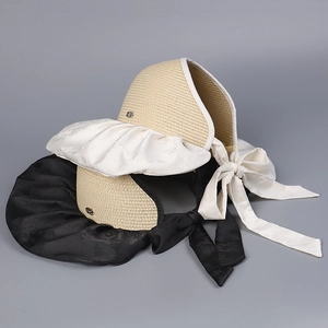 Détail d'un chapeau de soleil en satin jacquard avec nœud et bord large en crème et noir