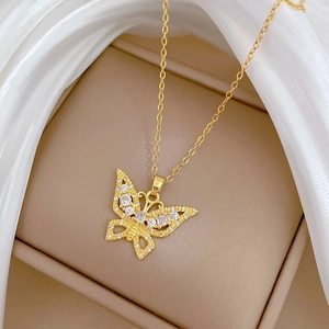 Macro shot of gold hollow butterfly necklace pendant with crystal zircon inlay on soft veil
