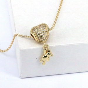 Golden bear necklace with heart pendant featuring sparkling stones and classic cross chain
