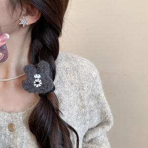 Detail of dark grey plush bear hair clip with soft fur texture for autumn and winter styles
