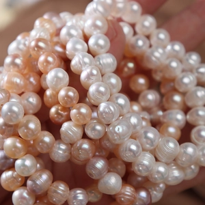 Natural freshwater pearl stretch bracelet in mixed pastel colors held in hand