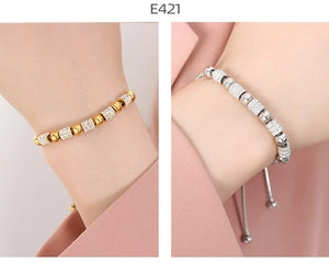 Detail of adjustable beaded bracelets in gold and silver finish with micro-pave zirconia