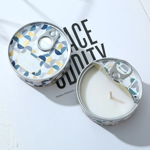 Top view of two colorful geometric tin candles with ring-pull lids showing white soy wax