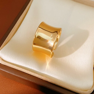 Detailed macro view of a polished wide-band golden open ring in a satin gift box