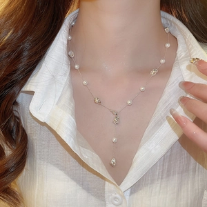 Close-up of elegant Y-shaped necklace with white pearls and irregular silver beads