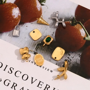 Macro shot of assorted gold and silver DIY charms like balloon dogs on a fashion magazine