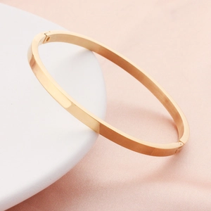 Minimalist rose gold stainless steel oval bangle with high-polished surface and hinge clasp