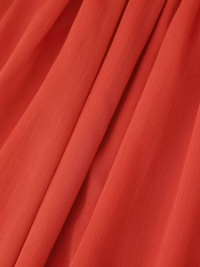 Macro shot of red pleated fabric texture showing vertical weave and drape quality