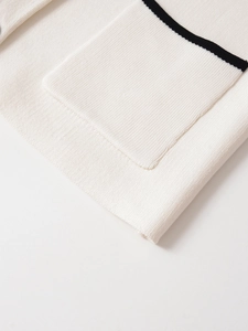 Detail of knit fabric texture with cream color and black contrast trim on the pocket edge