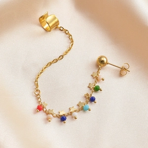 Detail of gold ear cuff and stud set with small star charms and colorful beads