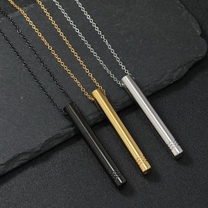 Three mindfulness breathing necklaces in black, gold, and silver on dark stone