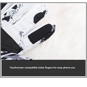 Close-up of winter ski gloves with touch-screen fingertips on black and white splatter pattern