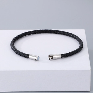 Détail macro du bracelet en cuir tressé noir pour hommes avec fermoir magnétique en acier