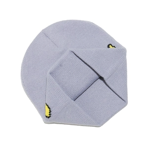 Dettaglio di un berretto in maglia viola con motivo jacquard a escavatore giallo