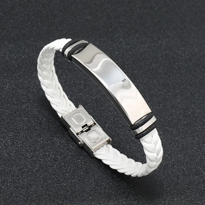 Detailed close-up of white braided leather bracelet with engraved silver stainless steel plate
