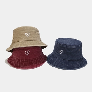 Detailed shot of cotton bucket hats with heart embroidery in khaki, burgundy, and navy