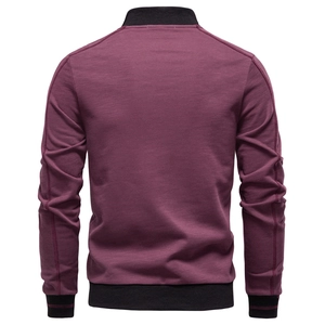Detail view of the back of a men's burgundy jacket with black ribbed collar and cuffs