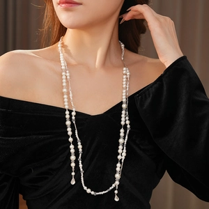 Collier de perles multicouche élégant avec pendentif goutte porté par un mannequin chic