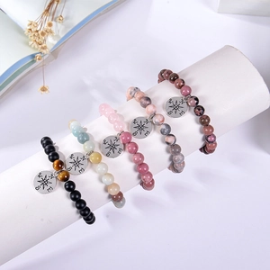 Detailed view of 8mm natural stone bead bracelets with compass star charms on a display stand