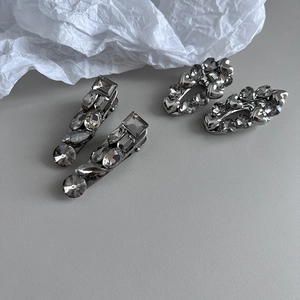 Close-up of dark silver metal hair clips with rectangular and oval inlaid crystals