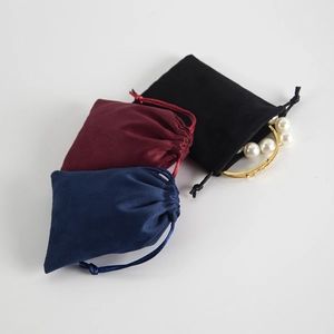 Velvet drawstring pouches for jewelry storage shown with a pearl bracelet in a macro view