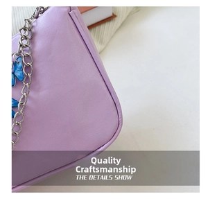 Detail view of lavender faux leather shoulder bag with silver chain and butterfly charms