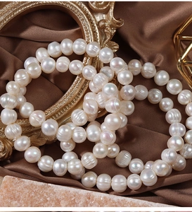 Macro shot of white freshwater pearls on dark silk with vintage frames and gold decor