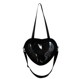 Detail of a black heart-shaped PU leather bag with transparent window and long strap