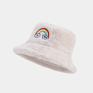 Détail du chapeau bob en peluche crème avec broderie arc-en-ciel et patch brodé