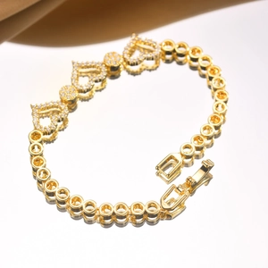 Macro shot of gold heart-shaped links and round links with sparkling white zircon stones