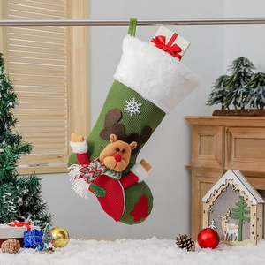 Chaussette de Noël en tricot vert avec peluche renne et motifs festifs dans un décor cosy