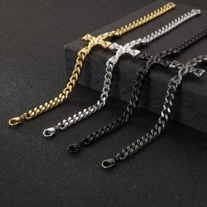 Detail of four colorful Cuban link cross bracelets displayed on a black textured gift box