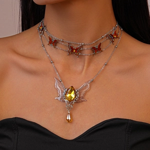 Detail of double-layer necklace with orange butterflies and yellow crystal pendant