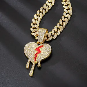 Gold Cuban link chain necklace with iced-out broken heart and red drip pendant