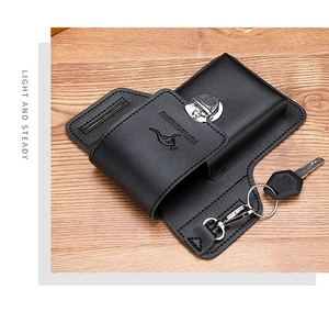 Detail of black leather phone holster with metal buckle and key ring on wood surface