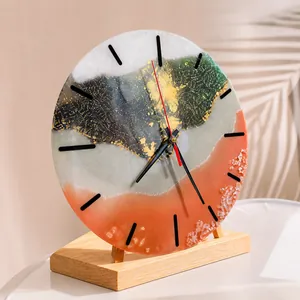 Artistic resin clock with orange and gold flowing pattern on a wooden display stand
