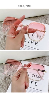Close-up of rimless oversized sunglasses with pink gradient lenses and gold metal frame