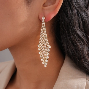 Close-up of elegant long waterfall tassel earrings with white rhinestones on a female model