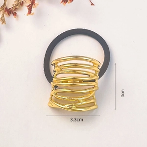 Detailed close-up of 3.3cm gold metal hair cuff with size markings on cream background