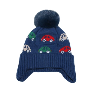 Detailed knit texture of blue winter earflap hat with colorful car patterns and pompom