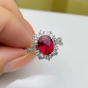 Elegant floral silver ring with deep red gemstone and surrounding small diamonds