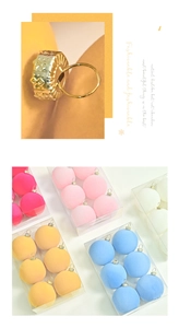Detail view of macaron flocked Christmas balls with golden engraved metal caps in box