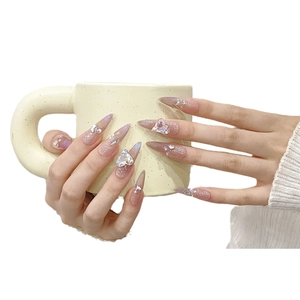 Long stiletto press-on nails with blush cat eye effect, heart rhinestones and crystals