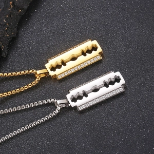 Macro detail of gold and silver razor blade pendants with CNC diamonds on pearl steel chains