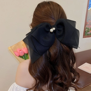 Grande pince à cheveux nœud en mousseline noire avec perles sur coiffure élégante