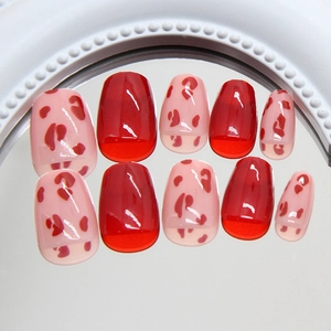 Glossy red leopard print press-on nails with ice-transparent finish on reflective surface