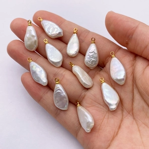 Natural freshwater baroque pearl drop pendant with golden clasp shown on hand