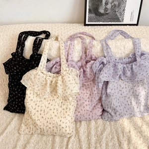 Detailed texture of floral print tote bags featuring ruffled edges and fabric patterns