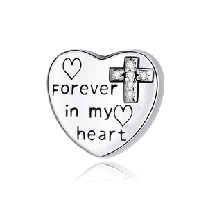 Detailed view of silver heart charm with 'Forever in my heart' engraving and small cross