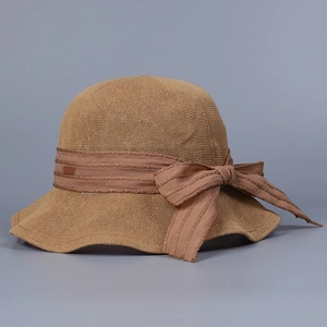 Close-up of khaki breathable knitted sun hat featuring a ribbon bow and metal logo tag